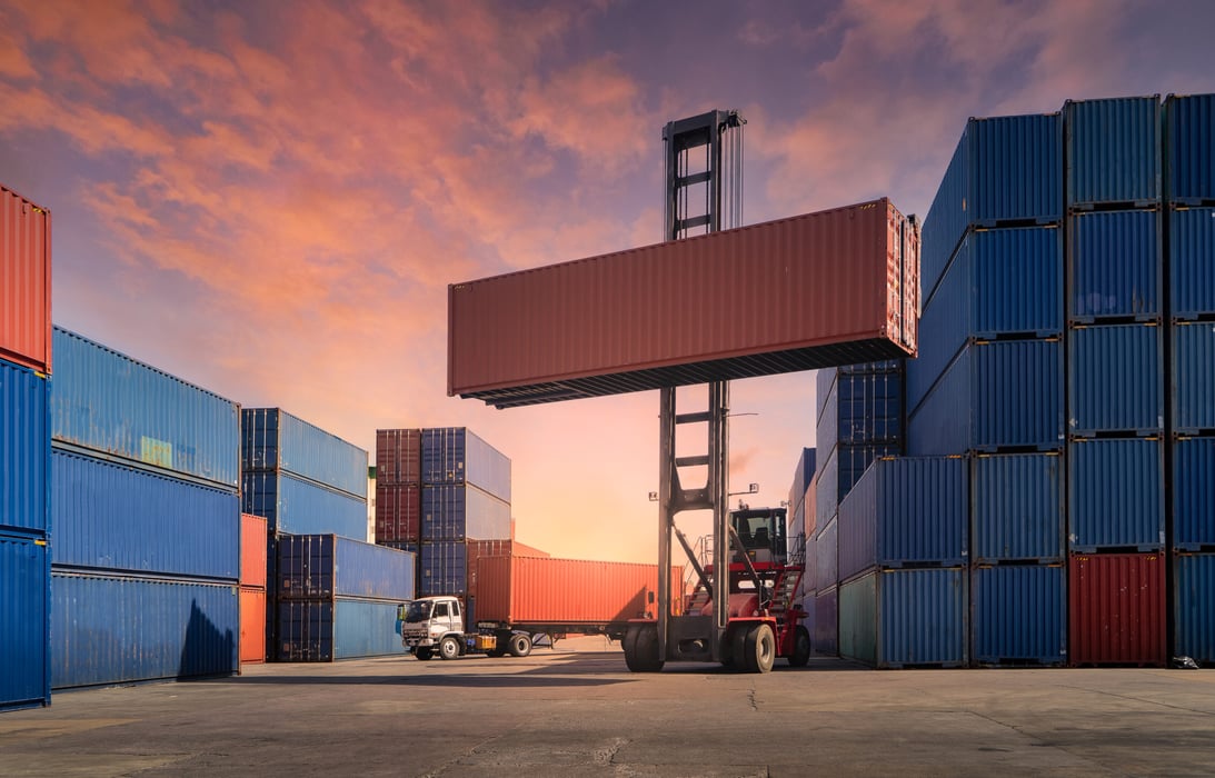 Engineers are overseeing the transportation of cargo with containers inside the warehouse.
