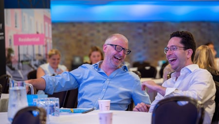 Cluttons colleagues laughing at a social event